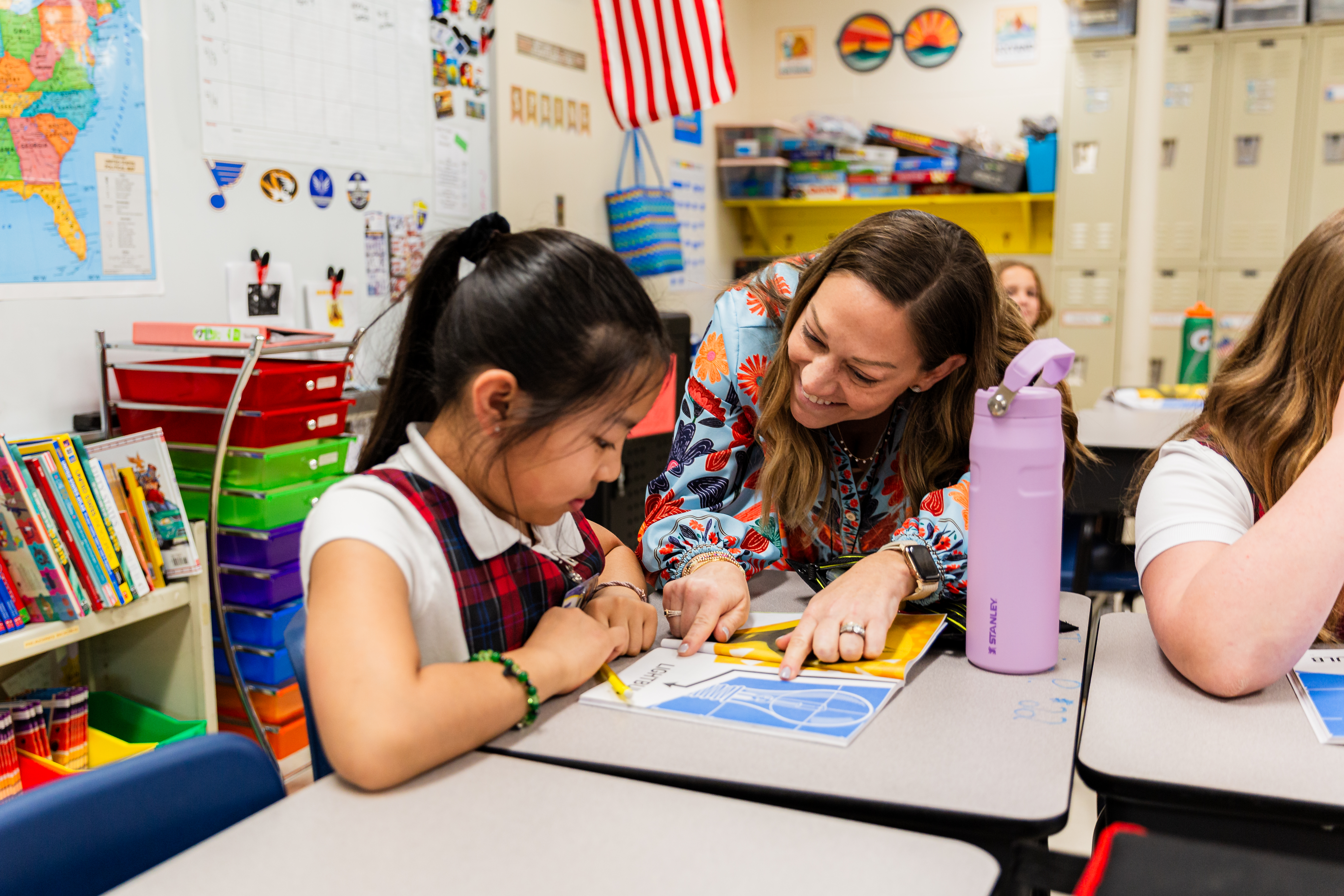 A teacher and student at a desk