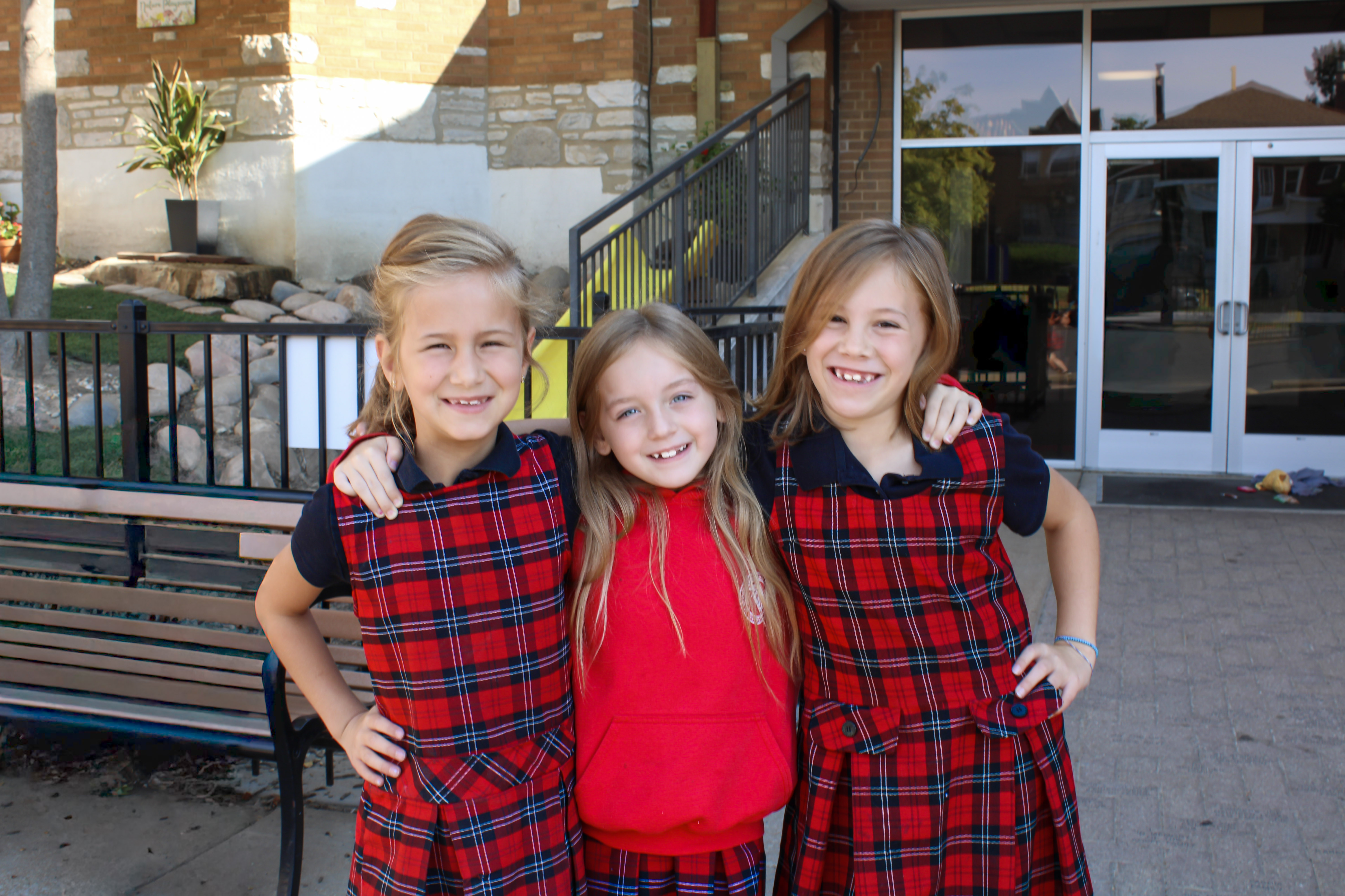 Three young students embraced and smiling
