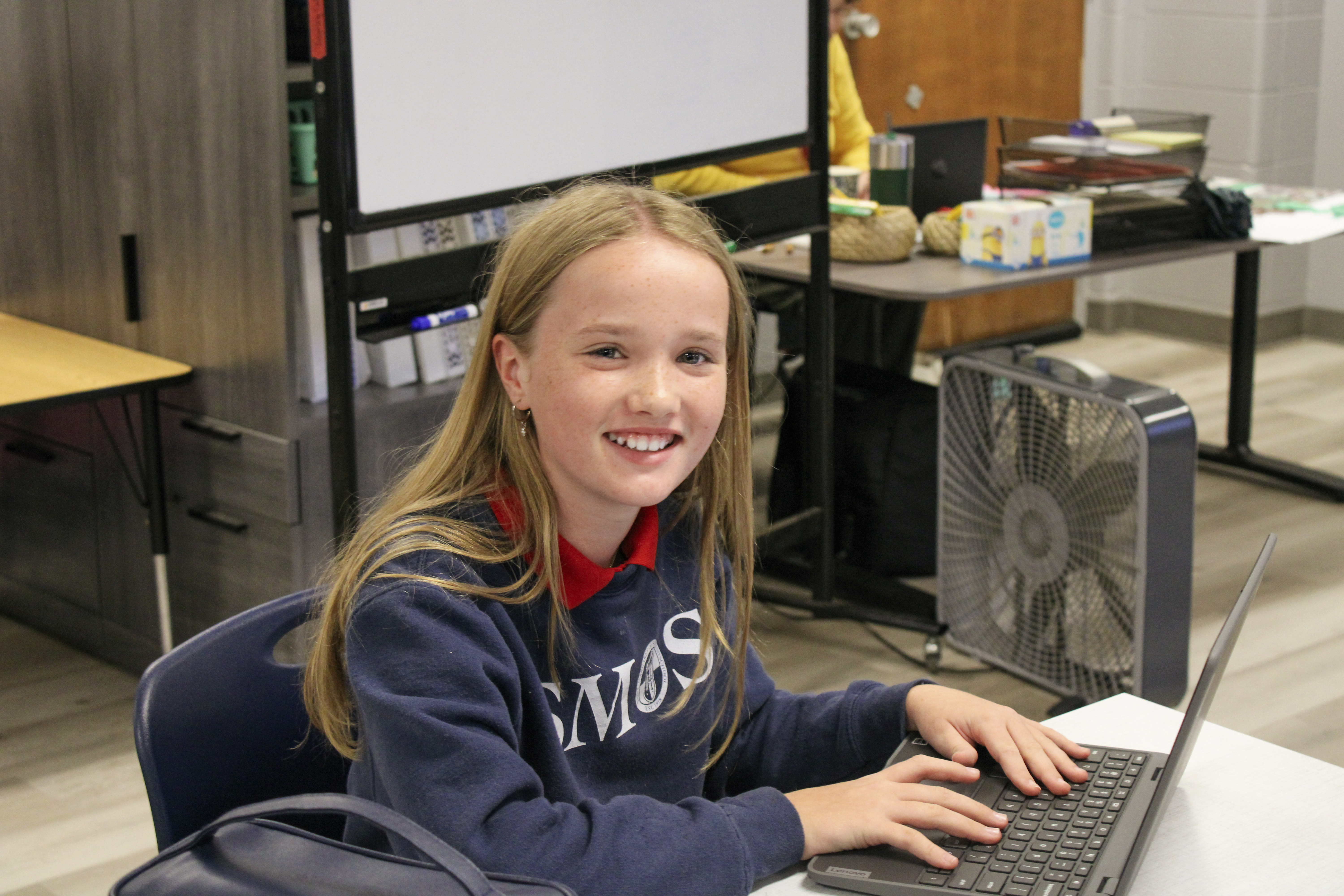High schol student at desk working on a laptop