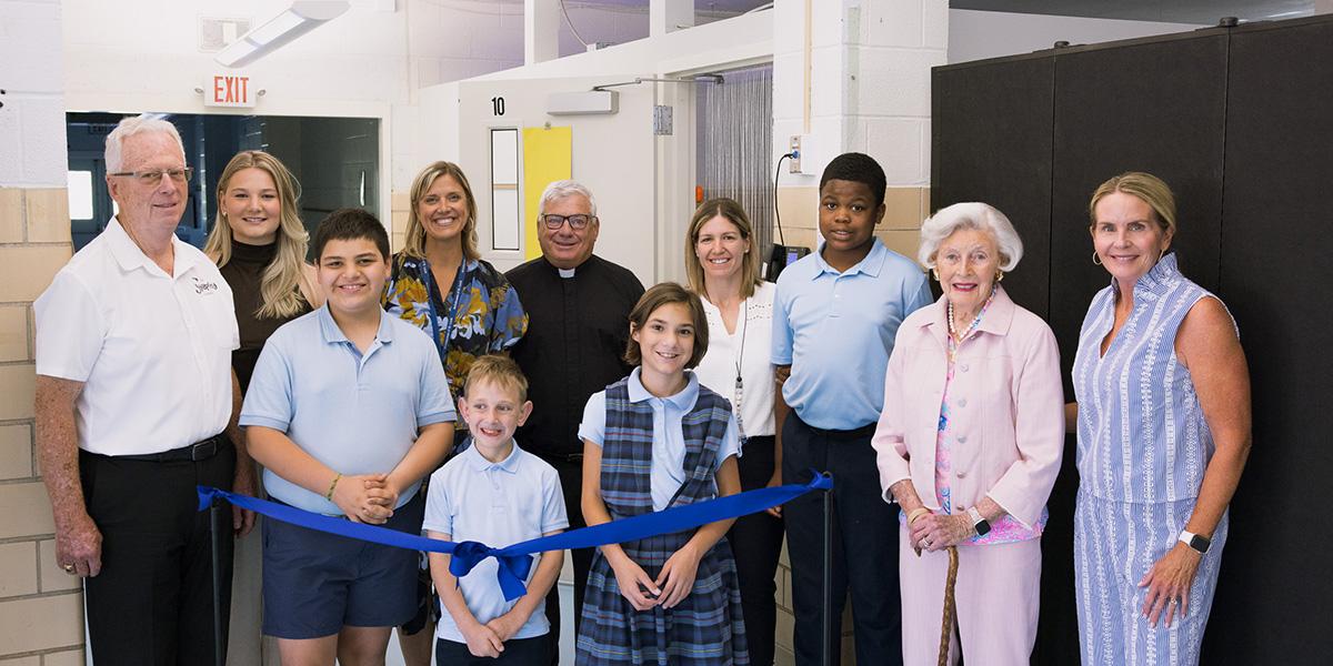 Supporters and benefactors gather around to cut the ribbon for Annunziata's new sensory room