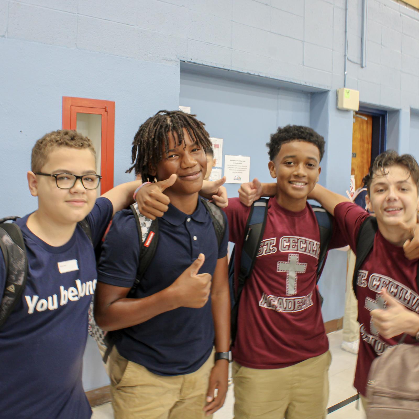 Four high school students with arms on shoulders